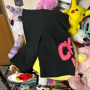 Black Calvin Klein shorts with graffiti CK in pink on the leg.